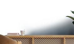 a potted plant sitting on top of a wooden shelf next to a chair and table