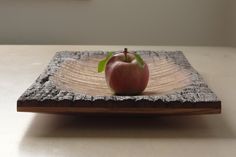 an apple sitting on top of a wooden plate