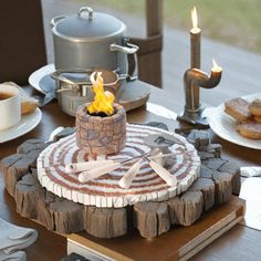 a wooden table topped with plates and cups filled with food next to a stove top oven