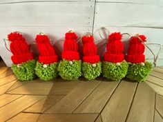 a row of red and green pom - poms sitting on top of a wooden floor