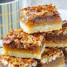 a stack of dessert bars sitting on top of a white plate