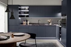 a modern kitchen with blue cabinets and counter tops is seen in this image from the dining room table