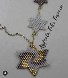 a cross stitched necklace with three stars on it