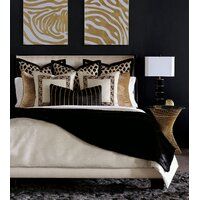 black and gold bedroom with zebra prints on the wall above the bed, two framed pictures over the headboard