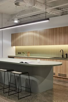 an empty kitchen with two stools next to the counter