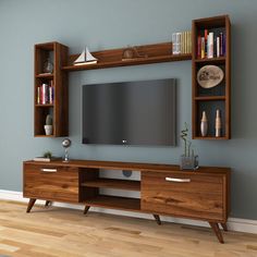 an entertainment center with bookshelves, shelves and a flat screen tv on the wall