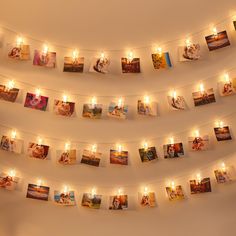 many pictures are hung on the wall and lit up with candles in front of them