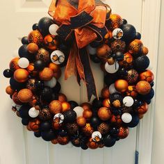 an orange and black halloween wreath on the front door