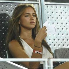 a beautiful young woman sitting next to a man holding a piece of paper in her hand