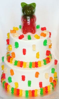 a gummy bear on top of a multi - layered cake with gummy bears