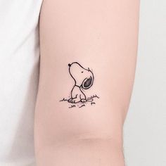 a person with a small tattoo on their arm that has a drawing of a dog