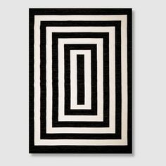 a black and white rug with an interlocked square pattern on the bottom half