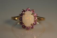 You will feel like royalty wearing this an impressive, gorgeous pink tourmalines and opal ring with your formal attire! This is a delightful piece to wear, comfortable and easy to wear everyday, large enough to be noticed but not overpowering. The pink tourmalines have a lovely soft pink hue and the solid Australian opal is just gorgeous.  For a captivating display, these stones are divine and stand out - this ring allows light to stream through the gemstones from various angles and illuminate t Elegant Pink Opal Ring, Elegant Pink Opal Gemstone Ring, Elegant Pink Opal Ring For Formal Occasions, Elegant Pink Opal Ring For Anniversary, Formal Pink Oval Opal Ring, October Birthday, Opal Ring, Australian Opal, Formal Attire