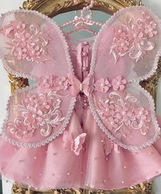 a pink dress with flowers and pearls on it