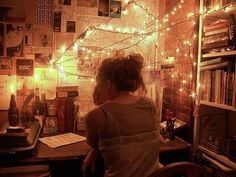 a woman sitting at a desk in front of a bookshelf filled with books