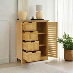 a wooden cabinet with drawers in a living room next to a potted plant and window