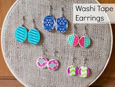 several pairs of earrings are displayed on a piece of fabric with the words washi tape earings