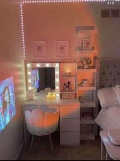 a bedroom with a vanity, mirror and lights on the wall above it's bed