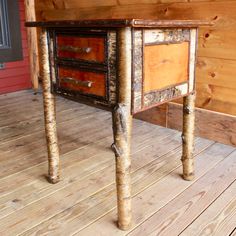 an old wooden table with two drawers on it