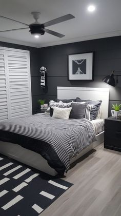 a bed room with a neatly made bed and a ceiling fan