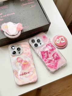 three cell phones sitting on top of a table next to a box with magnets