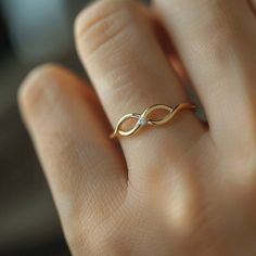 a woman's hand with a gold ring on it and a diamond in the middle