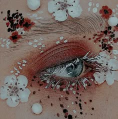 an eye is surrounded by flowers and petals