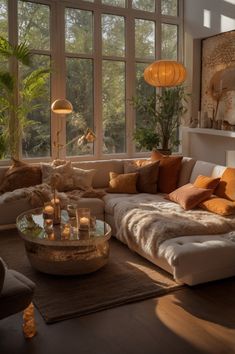 a living room filled with lots of furniture and large windows overlooking the trees in the distance