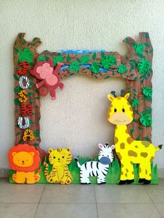 a group of wooden animals standing in front of a wall with an animal frame on it