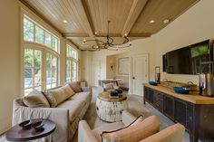 a living room filled with furniture and a flat screen tv mounted to the wall above it