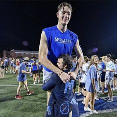 a man is hugging another man on the field