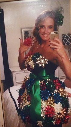 a woman taking a selfie in front of a christmas tree made out of tinsel