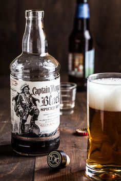 a bottle of captain morgan's spiced rum next to a glass of beer