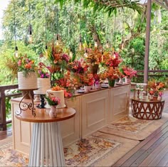 a table topped with cakes and flowers on top of a wooden floor covered in greenery