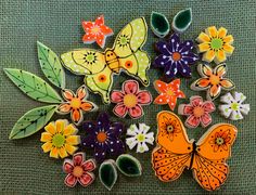 some colorful butterflies and flowers on a green surface