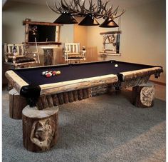 a pool table made out of logs and some lights