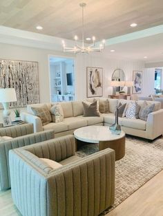 a living room filled with furniture and a chandelier hanging from the ceiling above