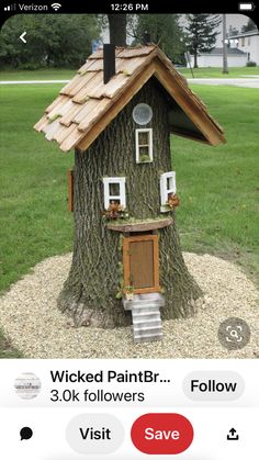 a tree house built into the side of a tree trunk with windows and shutters