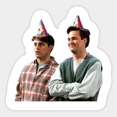 two men with party hats on their heads standing next to each other in front of a white background