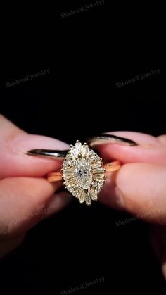 a woman's hand holding an engagement ring with a diamond center in the middle