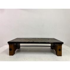 an old wooden coffee table sitting on top of a white floor