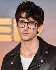 a man wearing glasses and a leather jacket