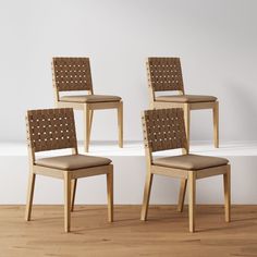 three wooden chairs sitting on top of a hard wood floor