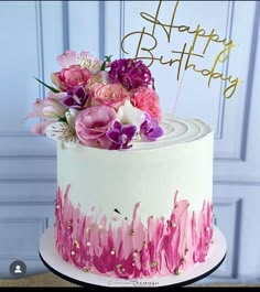 a white cake with pink and purple flowers on top