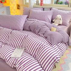 a bed with purple and white striped sheets