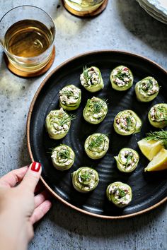 someone is holding a plate with small appetizers on it