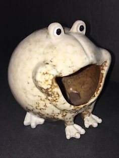 a white ceramic frog with its mouth open