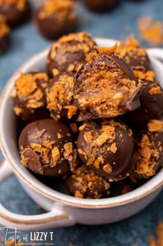 a white bowl filled with chocolate covered candies on top of a blue tablecloth