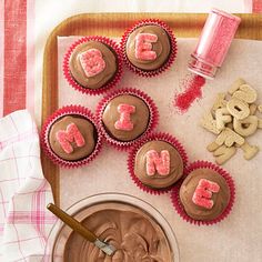 chocolate cupcakes with pink frosting and the word love spelled out on them