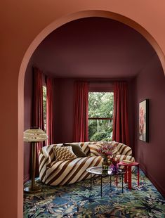 a living room filled with furniture and red curtains